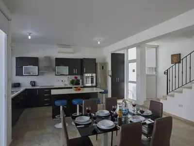 a kitchen and dining room with a table and chairs at Holiday Home in Paralimni mit geräumigem Garten by Interhome in Paralimni