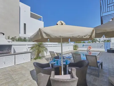 a patio with an umbrella and a table and chairs at Holiday Home in Paralimni mit geräumigem Garten by Interhome in Paralimni