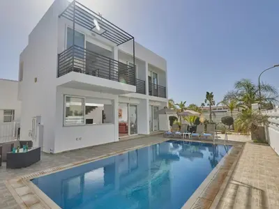 a large swimming pool in front of a house at Holiday Home in Paralimni mit geräumigem Garten by Interhome in Paralimni