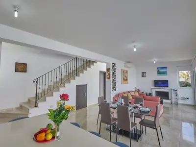 a dining room and living room with a table and chairs at Holiday Home in Paralimni mit geräumigem Garten by Interhome in Paralimni