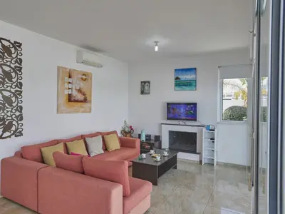a living room with a red couch and a fireplace at Holiday Home in Paralimni mit geräumigem Garten by Interhome in Paralimni