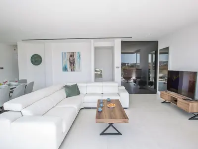 a white living room with a white couch and a table at Holiday Home Haus in Pernera mit Bi-Fold Patio by Interhome in Protaras