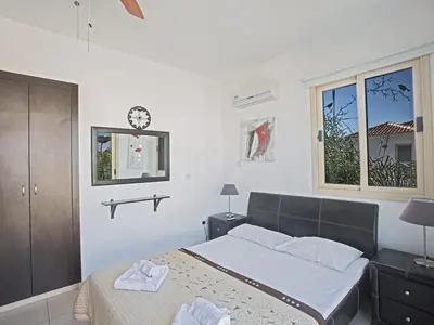 a bedroom with a bed and a clock on the wall at Holiday Home Ferienvilla PV17 mit Sonnenterrasse und Pool by Interhome in Protaras
