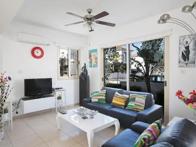 a living room with a blue couch and a table at Holiday Home Ferienvilla PV17 mit Sonnenterrasse und Pool by Interhome in Protaras
