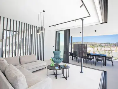 a living room with a couch and a table at Holiday Home Geräumige Villa mit großem Garten und Pool by Interhome in Protaras