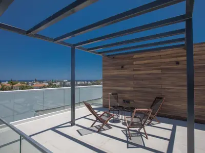 a patio with a table and chairs on a roof at Holiday Home Geräumige Villa mit großem Garten und Pool by Interhome in Protaras