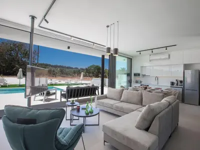 a living room with a couch and chairs and a pool at Holiday Home Geräumige Villa mit großem Garten und Pool by Interhome in Protaras