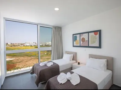 two beds in a room with a large window at Holiday Home Ferienvilla Vie Bleu mit großem Pool by Interhome in Protaras