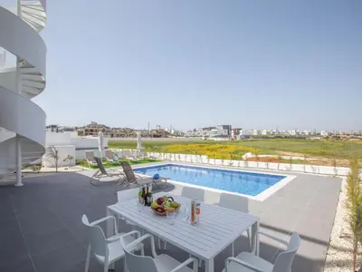 a patio with a table and chairs and a swimming pool at Holiday Home Ferienvilla Vie Bleu mit großem Pool by Interhome in Protaras