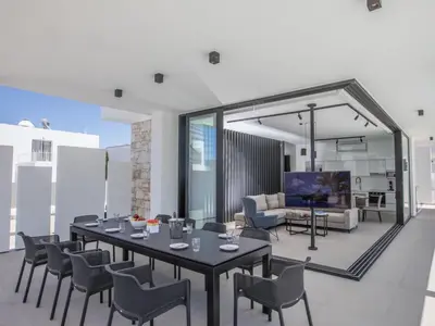 a living room with a table and chairs at Holiday Home in Protaras mit großem Garten by Interhome in Protaras