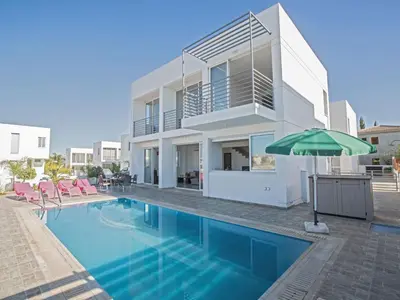 a house with a swimming pool and an umbrella at Holiday Home Protaras Perle Villa PE16 by Interhome in Protaras