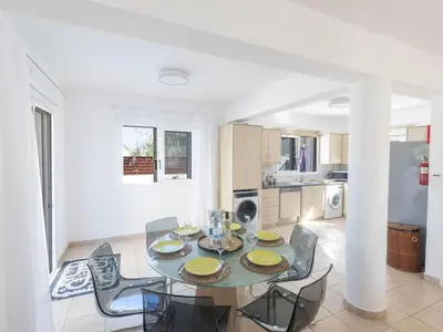 a dining room with a table and chairs and a kitchen at Holiday Home Protaras Blauer Fluss Villa BR26 by Interhome in Protaras