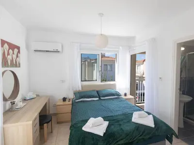 a bedroom with a bed and a sink and a mirror at Holiday Home Protaras Blauer Fluss Villa BR26 by Interhome in Protaras