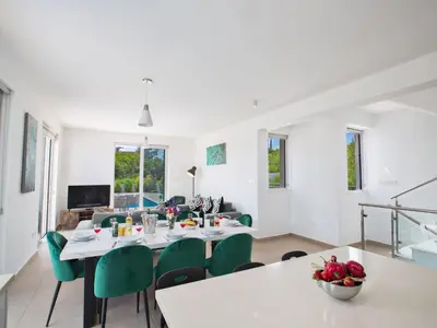 a dining room with a table and green chairs at Holiday Home Schöne- topmoderne Ferienvilla auf Zypern by Interhome in Protaras