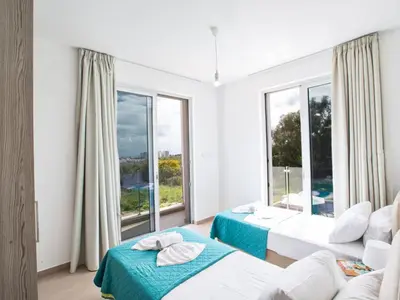 a bedroom with two beds and a large window at Holiday Home Schöne- topmoderne Ferienvilla auf Zypern by Interhome in Protaras