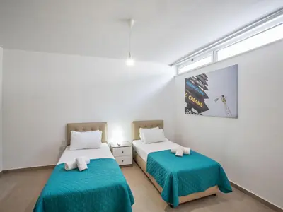two beds in a room with white walls at Holiday Home Schöne- topmoderne Ferienvilla auf Zypern by Interhome in Protaras