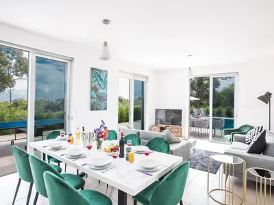 a dining room with a white table and green chairs at Holiday Home Schöne- topmoderne Ferienvilla auf Zypern by Interhome in Protaras
