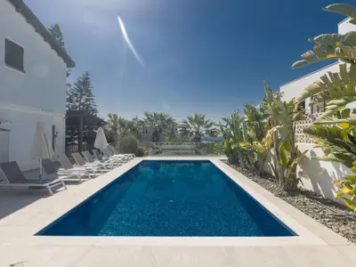 a swimming pool with chairs and a house at Holiday Home Ferienvilla Mo 3 für 10 Personen in Agia Napa by Interhome in Ayia Napa