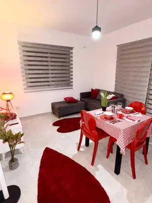 a living room with a table and red chairs at Lapta Red 1 bedroom apartment