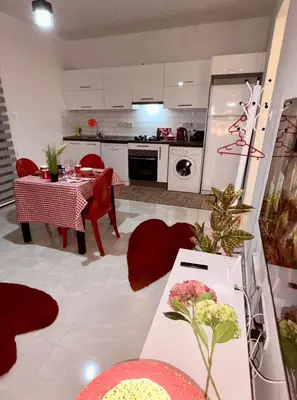 a kitchen and dining room with a table and red chairs at Lapta Red 1 bedroom apartment