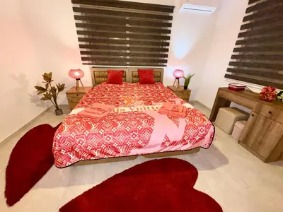 a bedroom with a large bed with red sheets and red pillows at Lapta Red 1 bedroom apartment