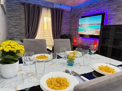 a dining room table with plates of food and a television at Lights of Paradise - Your Happy Escape in Ayia Napa
