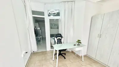 a white office with a desk and a chair at Silver Blu APT - Beachside - Location - Office in Limassol