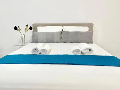 a bedroom with a bed with towels on it at Silver Blu APT - Beachside - Location - Office in Limassol