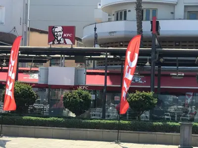 two red and white flags in front of a restaurant at Queen victoria sea view apartments in Larnaka