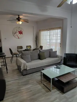 a living room with a couch and a table at Queen victoria sea view apartments in Larnaka