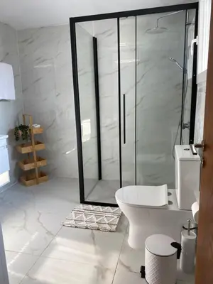 a white bathroom with a shower and a toilet at Barbaras House in Kato Pyrgos