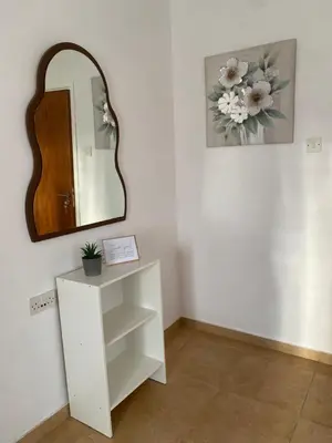 a mirror on a wall next to a white cabinet at Barbaras House in Kato Pyrgos