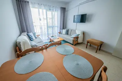 a living room with a wooden table with chairs and a couch at Trinidad, 1 - A in Paralimni
