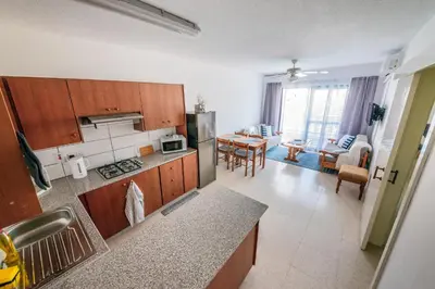 a kitchen with wooden cabinets and a dining room at Trinidad, 1 - A in Paralimni
