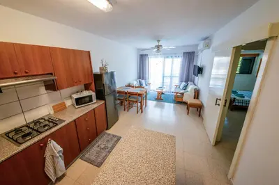 a kitchen with wooden cabinets and a dining room at Trinidad, 1 - A in Paralimni