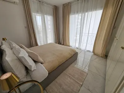 a bedroom with a bed and a large window at Beach Front View Apartment Sea Pool & Prime Location in Limassol