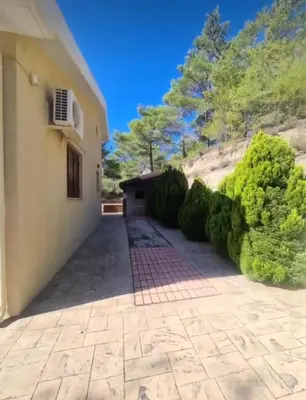 a driveway leading to a house with bushes at Maria's Garden House in Pelendri