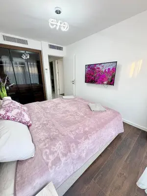a bedroom with a large bed with a pink blanket at Brand new 2 bedrooms apartment in Grand Sapphire in İskele