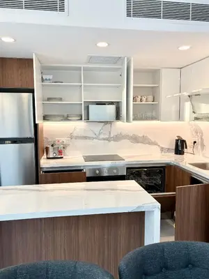 a kitchen with white counters and a refrigerator at Brand new 2 bedrooms apartment in Grand Sapphire in İskele