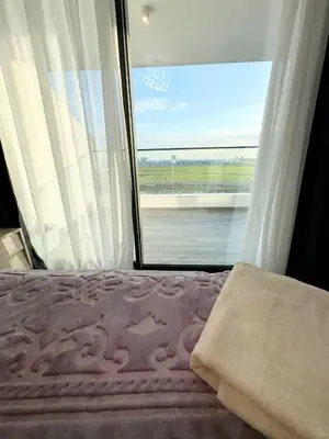 a bedroom with a bed and a large window at Brand new 2 bedrooms apartment in Grand Sapphire in İskele