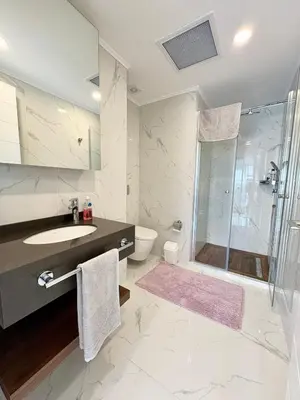 a white bathroom with a sink and a shower at Brand new 2 bedrooms apartment in Grand Sapphire in İskele
