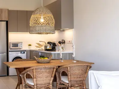 a kitchen with a wooden table with wicker chairs at Mythical seas 004 in Paralimni