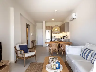 a living room with a white couch and a table at Mythical seas 004 in Paralimni