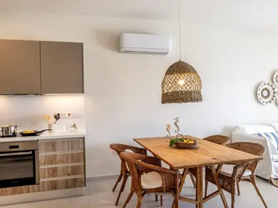 a kitchen and dining room with a wooden table and chairs at Mythical seas 004 in Paralimni