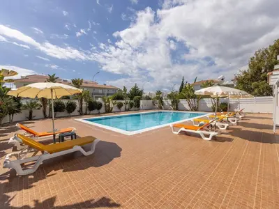a swimming pool with lounge chairs and umbrellas at Mythical seas 004 in Paralimni
