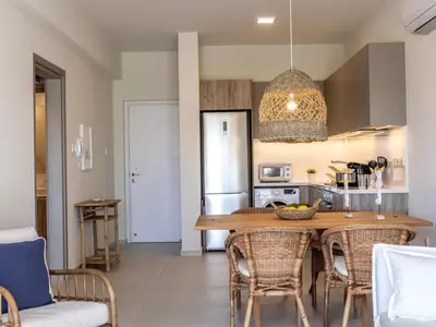a kitchen with a wooden table and chairs in a room at Mythical seas 004 in Paralimni