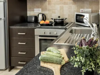a kitchen with a counter with cucumbers on a cutting board at Mythical Sands CB04 in Paralimni