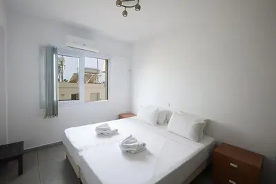 a bedroom with a white bed with towels on it at Napa Apollo 's Nest in Ayia Napa