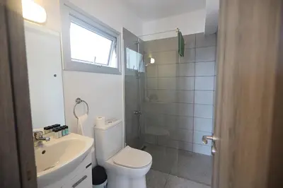 a white bathroom with a toilet and a sink at Napa Apollo 's Nest in Ayia Napa