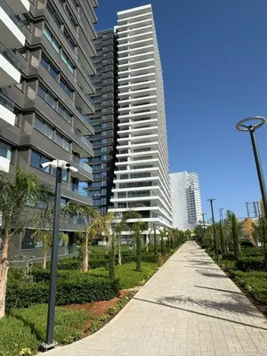 a sidewalk in front of a tall building with palm trees at Super Luxury 1 bedroom apartment on 27th floor in Grand Sapphire in Phrenaros